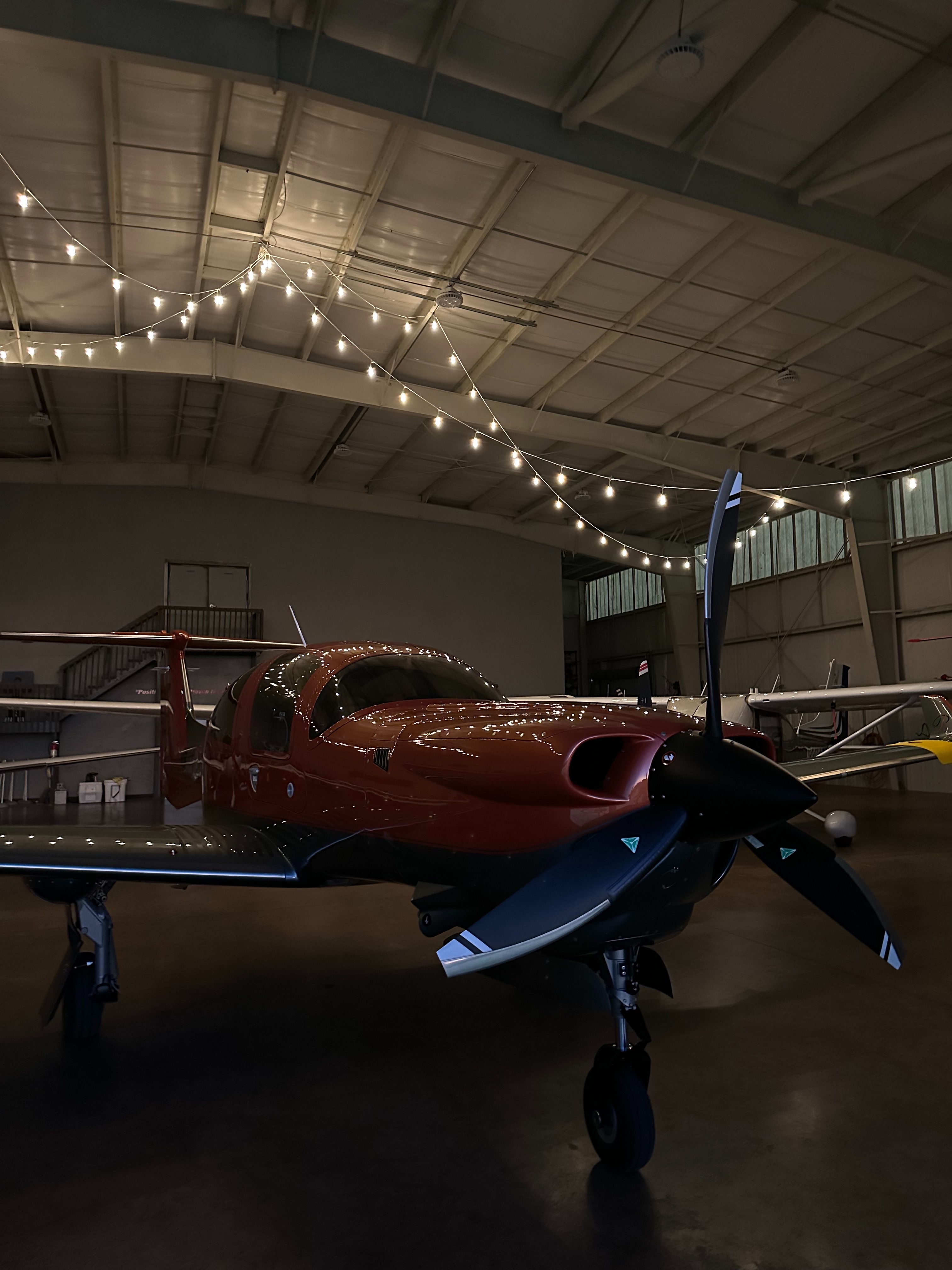 Red aircraft parked in a hangar before an ownership review